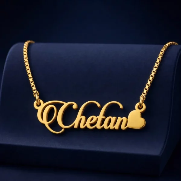 Gold-tone decorative script name necklace with a heart on a navy velvet display