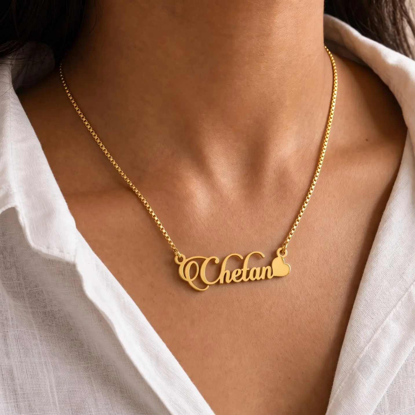 Stylish Heart Name Necklace - Worn View Gold-tone decorative script name necklace with a heart worn with a white blouse