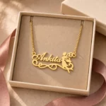 Gold-tone fairy silhouette name pendant displayed in an open beige jewellery box