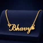 Gold-tone curved script name necklace with a heart on a navy velvet display