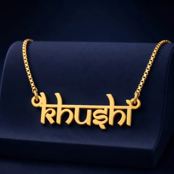 Gold-tone Indian style name necklace on a navy velvet display