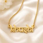 Gold-tone Indian style name necklace on ivory satin