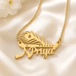 Gold-tone peacock feather and flute name pendant on ivory satin