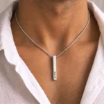 Silver-tone personalized 3D bar pendant with an engraved name worn with a white blouse