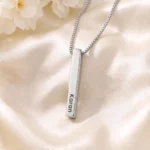 Silver-tone personalized 3D bar pendant with an engraved name on ivory satin
