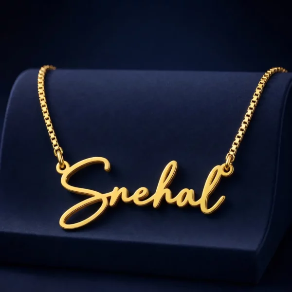 Gold-tone signature script name necklace on a navy velvet display