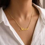 Gold-tone simple script name necklace worn with a white blouse