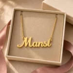 Gold-tone simple script name necklace displayed in an open beige jewellery box