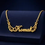 Gold-tone angel wings name necklace on a navy velvet display