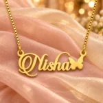 Gold Nisha butterfly name necklace on champagne blush organza
