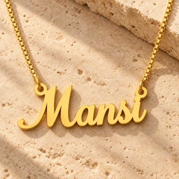 Gold Mansi script name necklace on warm textured stone