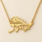 Gold Priya name pendant with peacock feather and flute design, golden box chain, clean ivory product view