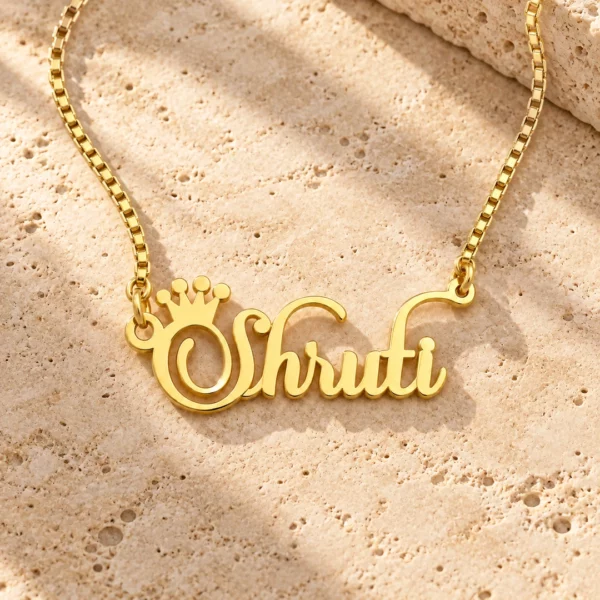 Crown Name Necklace with original gold box chain on travertine hero background
