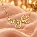 Cursive Curved Name Necklace with original gold box chain on blush organza background