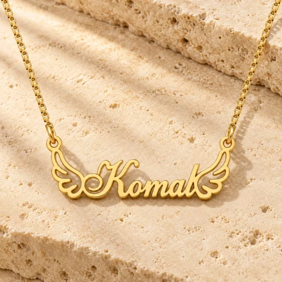 Angel Wings Name Necklace on a rough stone surface