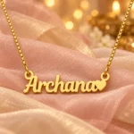 Gold Archana name pendant with solid heart and box chain on blush organza