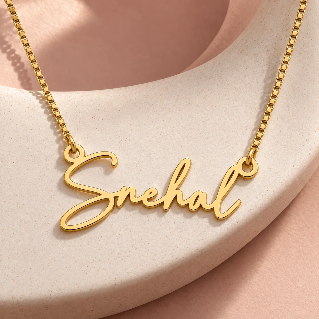 Signature Style Name Necklace — Ceramic concept Gold Snehal signature name pendant and box chain on curved ceramic