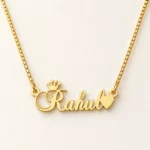 Gold Rahul crown and heart name necklace with original box chain - ivory studio background