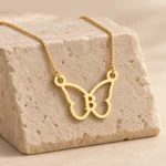 Butterfly Shape Letter Pendant with a chain on a stone display