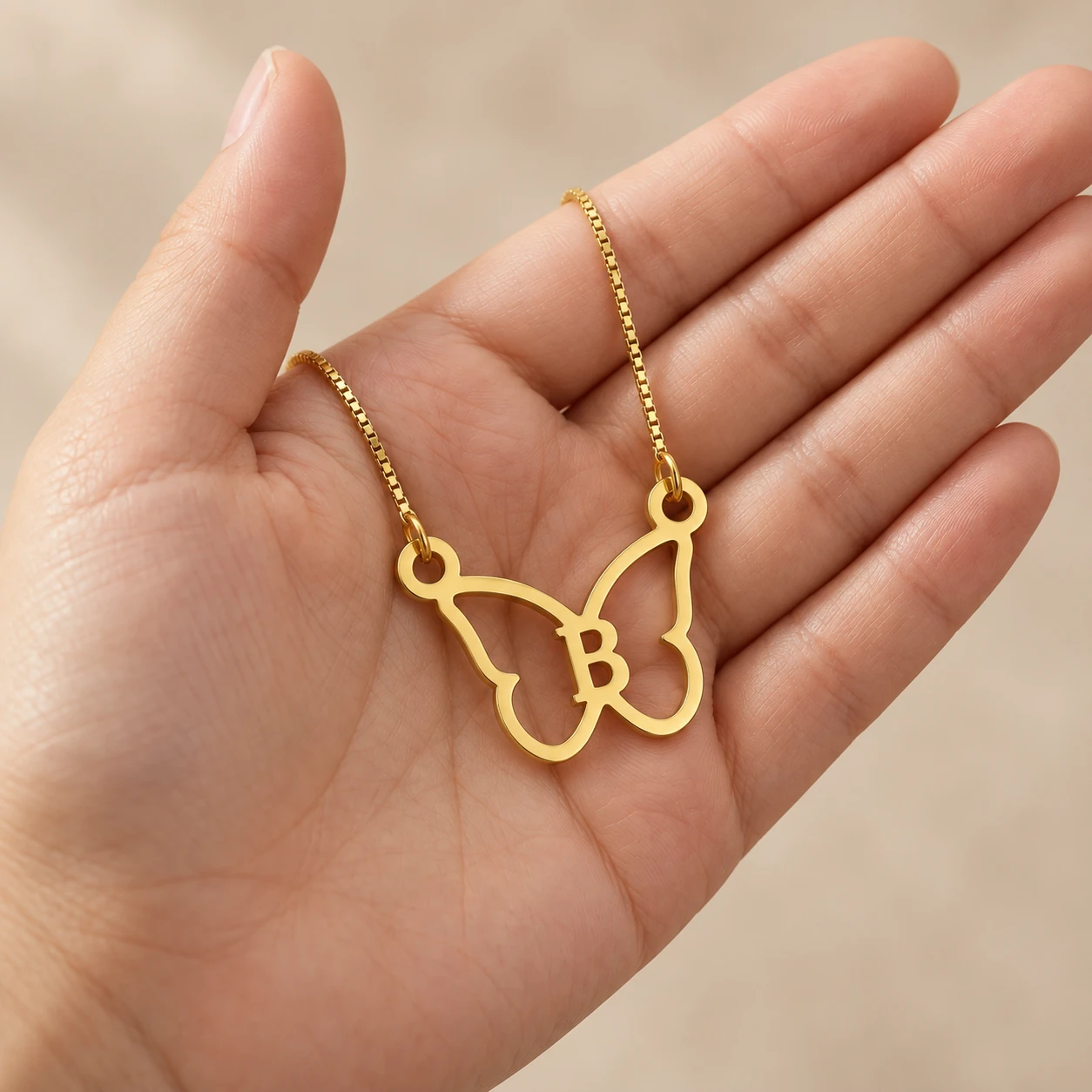 Butterfly Shape Letter Pendant - With a chain held in a hand Butterfly Shape Letter Pendant with a chain held in a hand