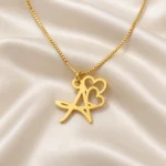 Double Heart Letter Pendant with a chain on cream fabric