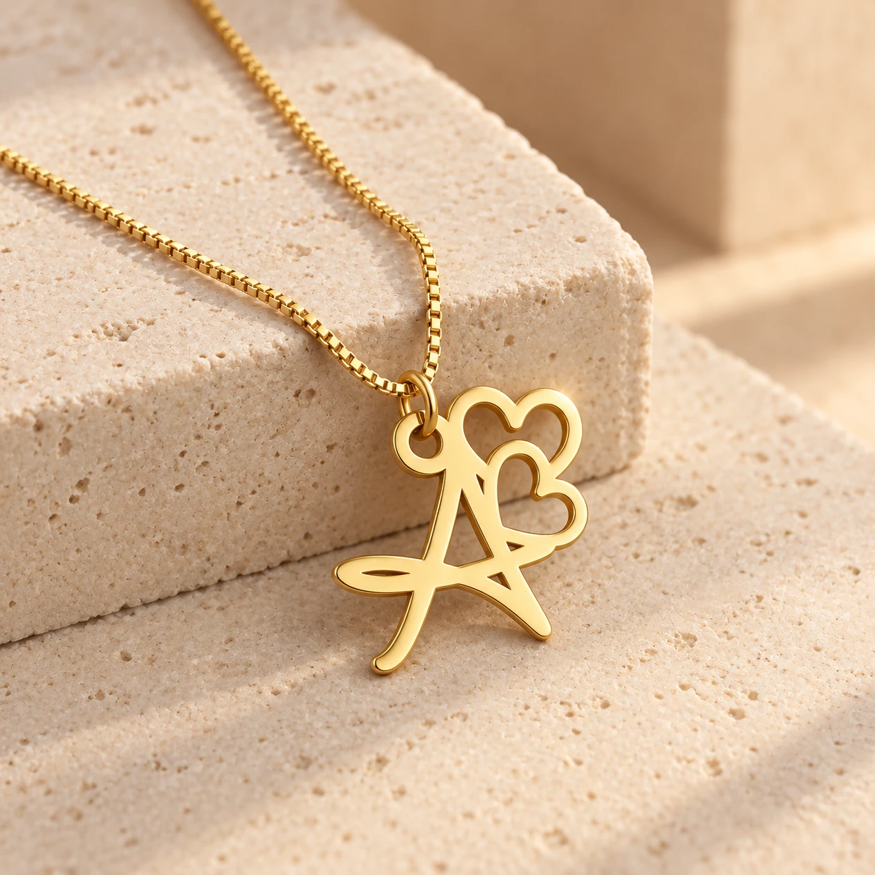 Double Heart Letter Pendant - With a chain on a stone display Double Heart Letter Pendant with a chain on a stone display