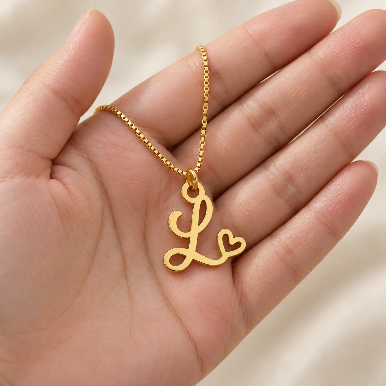 Curved Heart Letter Pendant - With a chain held in a hand Curved Heart Letter Pendant with a chain held in a hand