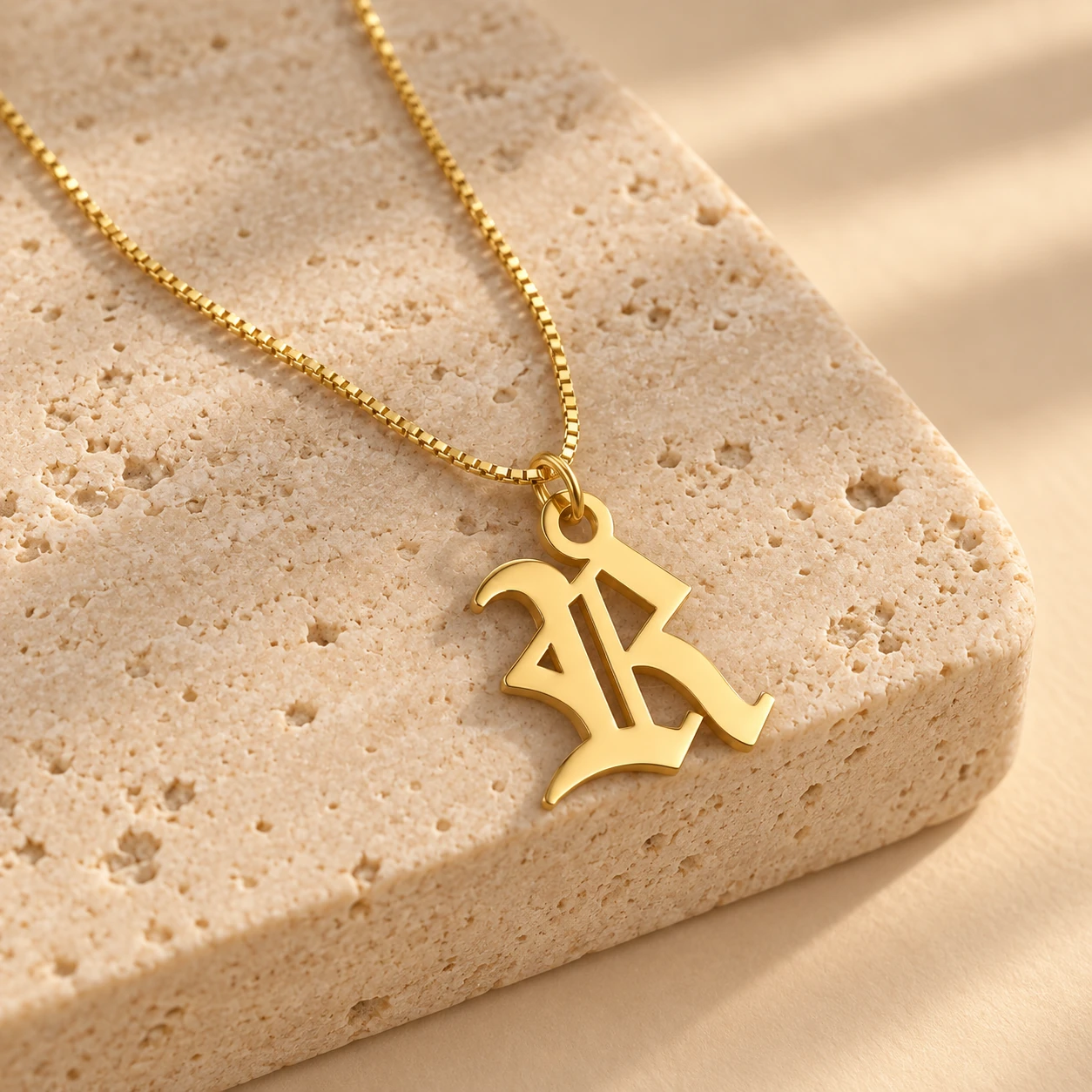 Old English Letter Pendant - With a chain on a stone display Old English Letter Pendant with a chain on a stone display