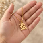 Old English Letter Pendant with a chain held in a hand
