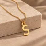 Simple Letter Pendant with a chain on a stone display