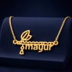 Gold-tone flute and feather name pendant on a navy velvet display