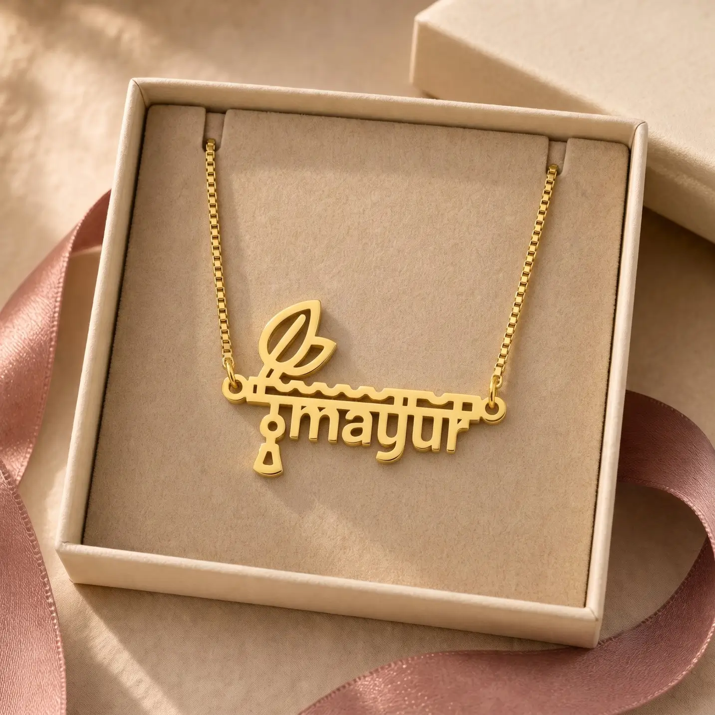 Flute and Feather Name Pendant - Jewellery Box Gold-tone flute and feather name pendant displayed in an open beige jewellery box