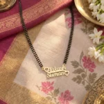 Heart Detail Couple Name Necklace with a black-beaded chain on floral fabric