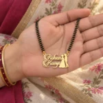 Couple Design Name Necklace with a black-beaded chain held in a hand