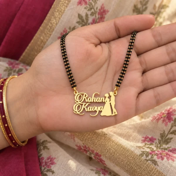 Couple name necklace with black-bead chain resting on a hand