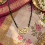 Umbrella Couple Name Necklace with a black-beaded chain on floral fabric