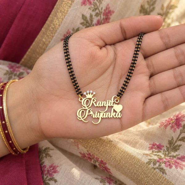Diamond couple name necklace with black-bead chain resting on a hand