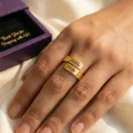 Personalized Engraved Couple Name Ring shown on a hand beside a box
