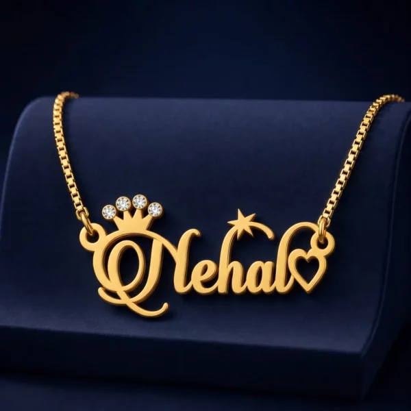 Gold-tone name necklace with a sparkling crown, star and heart on a navy velvet display