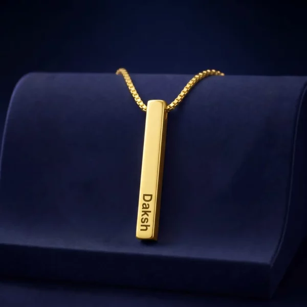 Gold-tone personalized 3D bar pendant with an engraved name on a navy velvet display