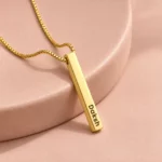 Gold Plated Personalized 3D Bar Pendant necklace on rose ceramic surface
