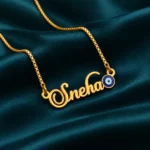 Blue Evil Eye Name Necklace on dark green fabric