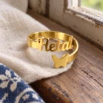 Personalized Butterfly Name Ring displayed on beige linen beside a wooden window