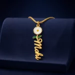 Gold-tone vertical name pendant with a daisy flower on a navy velvet display