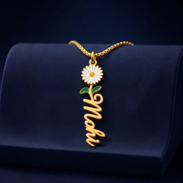 Gold-tone vertical name pendant with a daisy flower on a navy velvet display