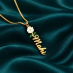 Flower Drop Name Necklace on dark green fabric