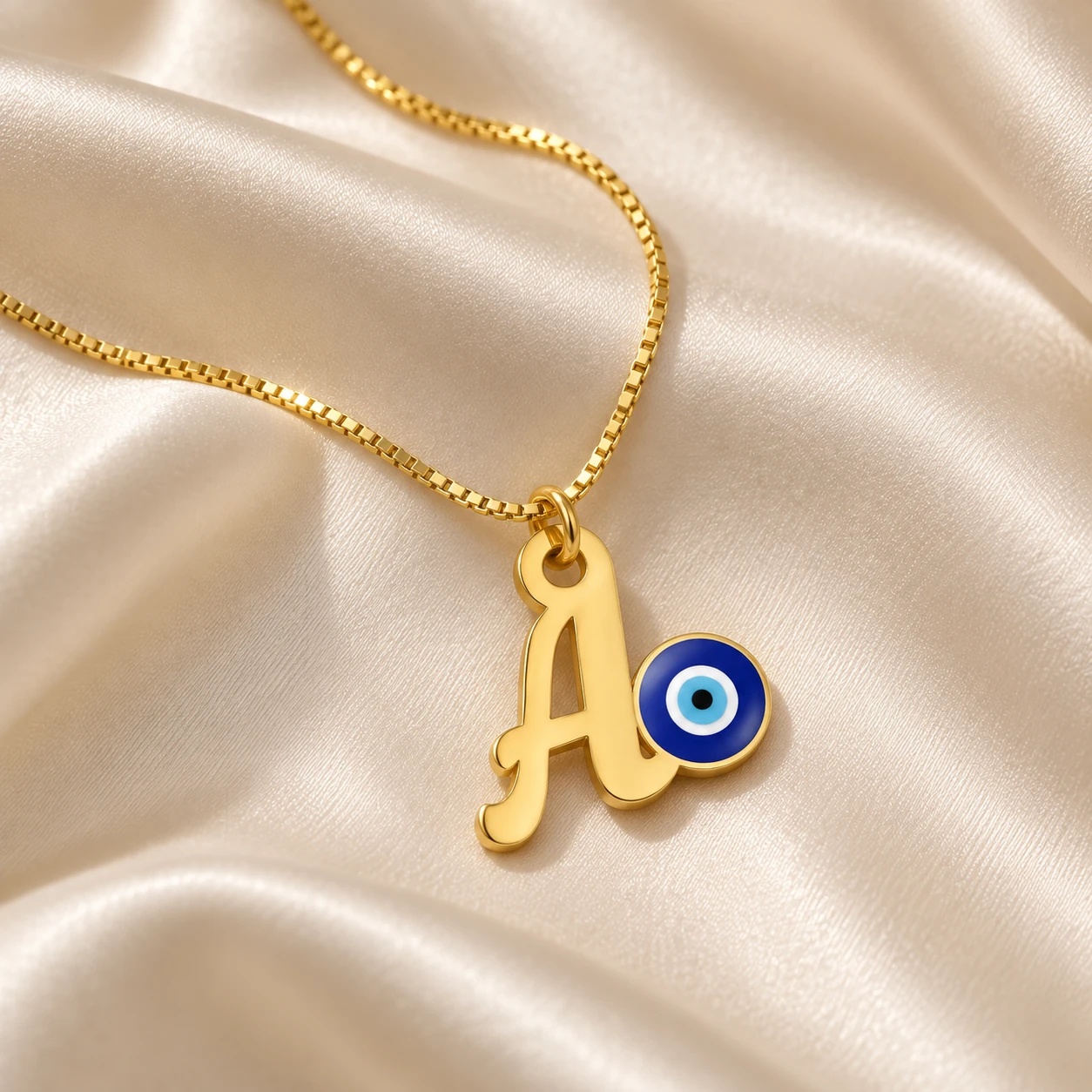 Blue Evil Eye Letter Pendant - With a chain on cream fabric Blue Evil Eye Letter Pendant with a chain on cream fabric
