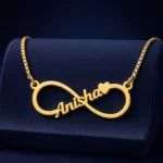 Gold-tone infinity outline name necklace on a navy velvet display