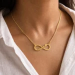 Gold-tone infinity outline name necklace worn with a white blouse