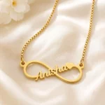 Gold-tone infinity outline name necklace on ivory satin